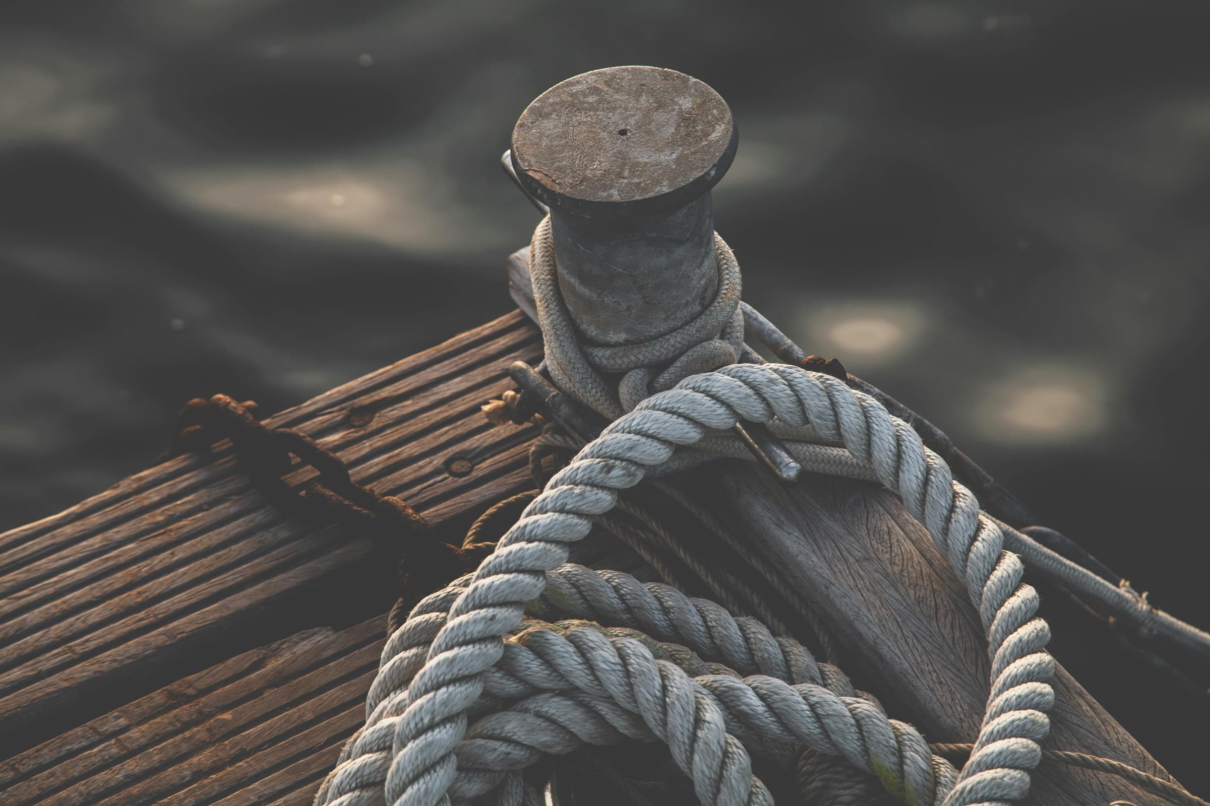 Mooring rope coiled on a sun-bleached wooden dock